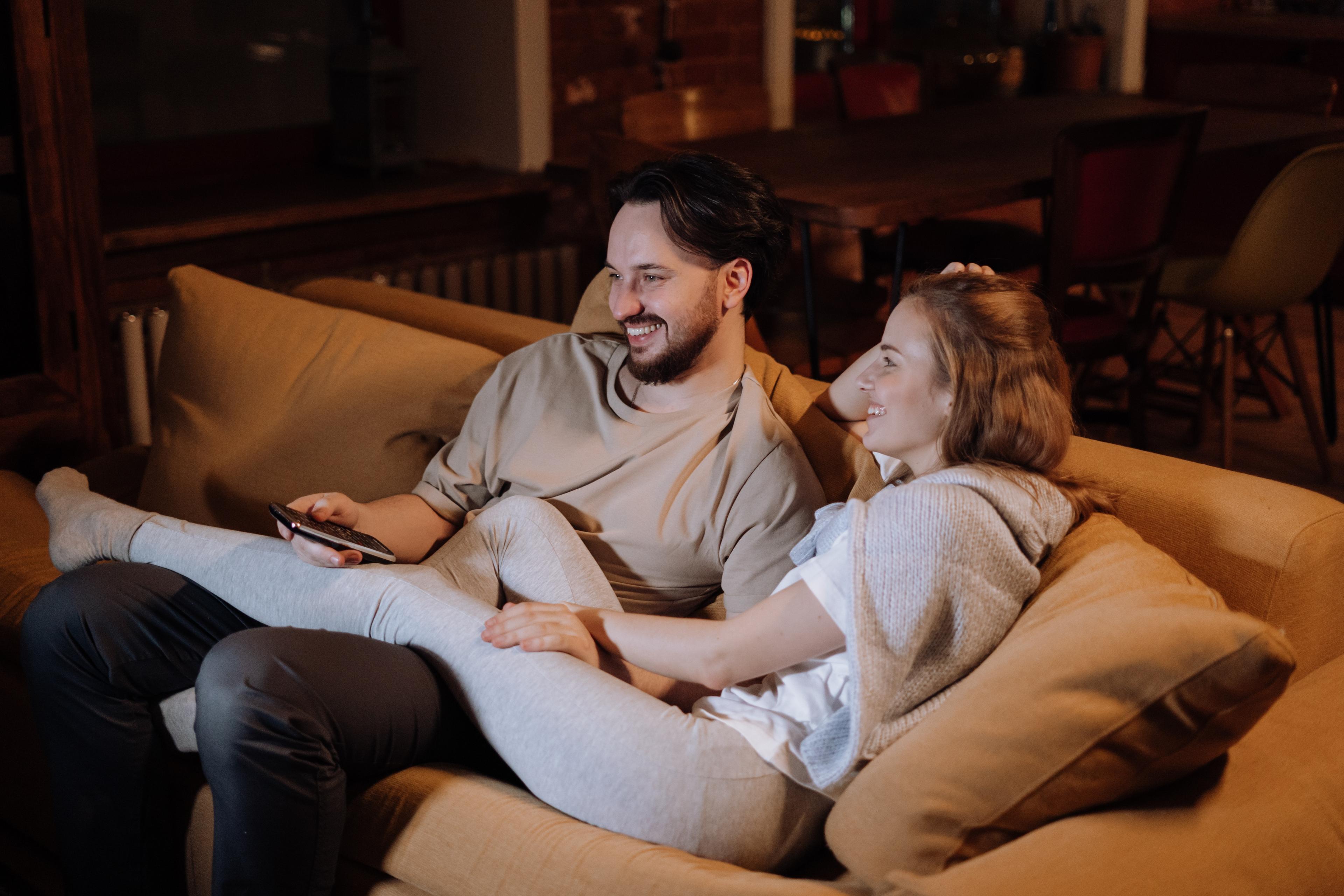 Couple watching TV on sofa in living room